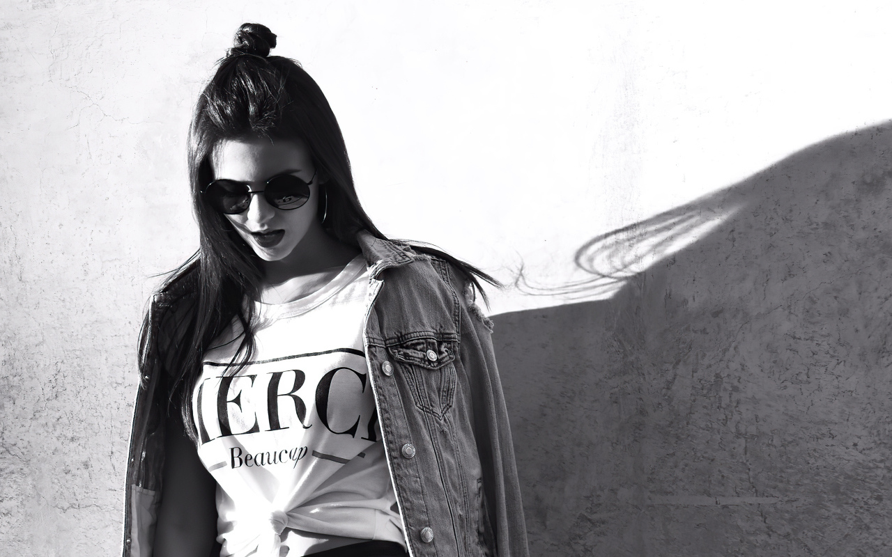 Актриса  Виктория Джастис в очках у стены