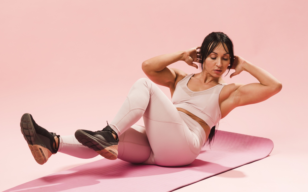 Спортивная девушка качает пресс на коврике