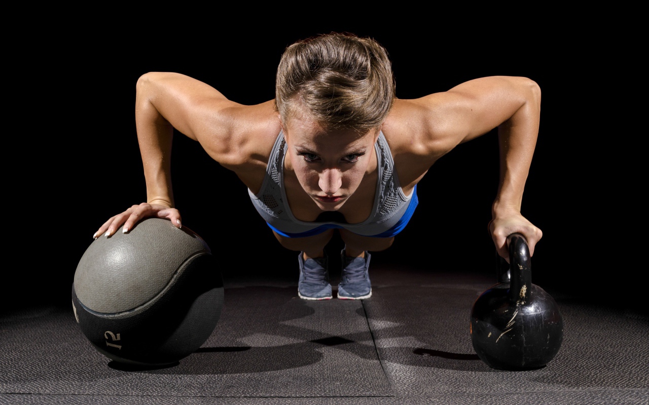 Девушка отжимается с гирями