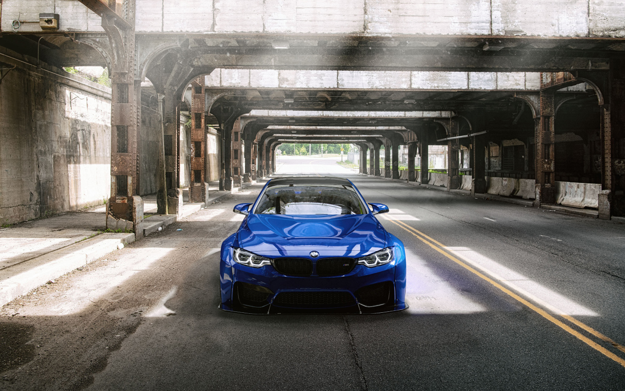 Синий автомобиль BMW M4 под мостом
