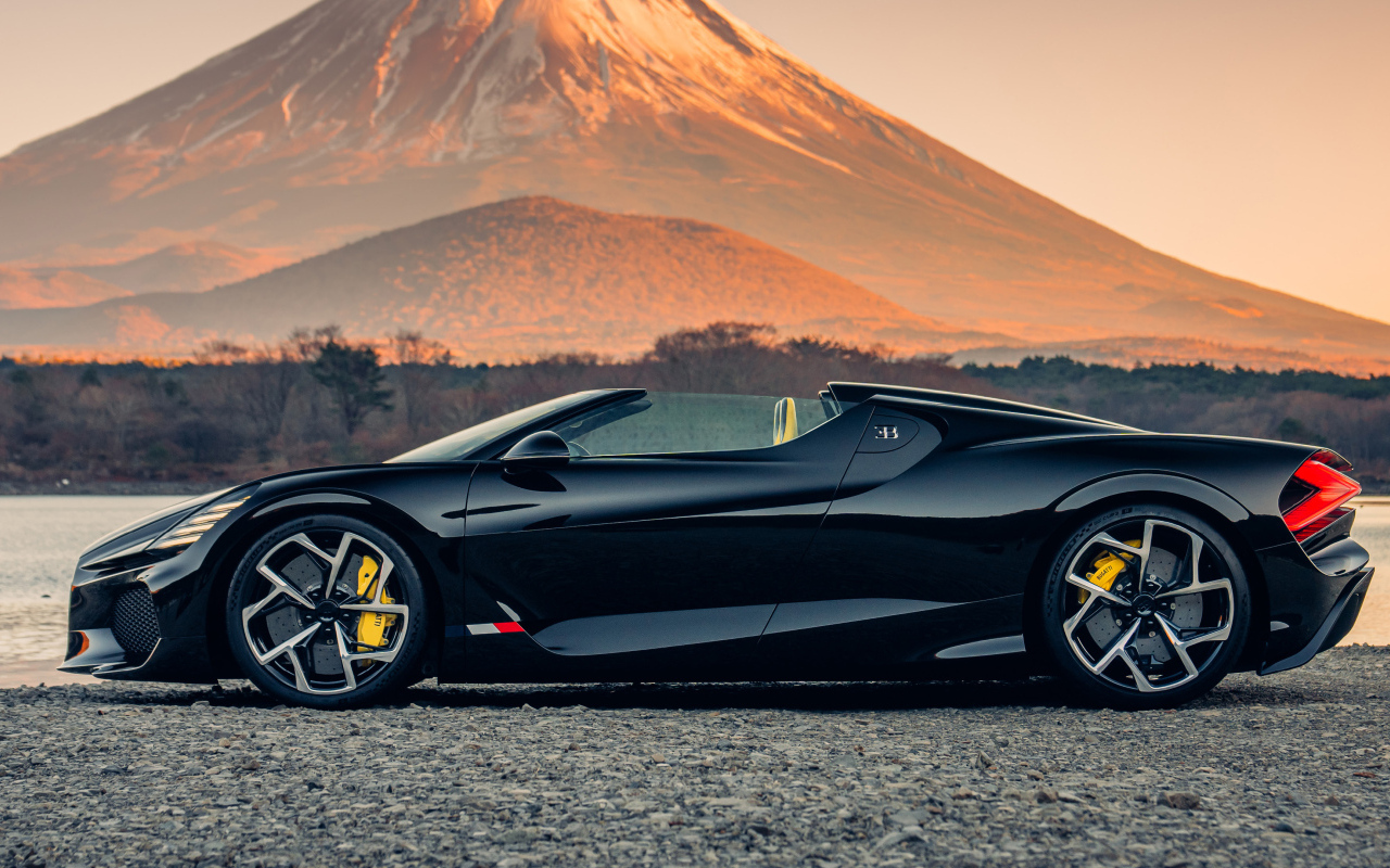 Черный автомобиль Bugatti W16 Mistral  на фоне горы