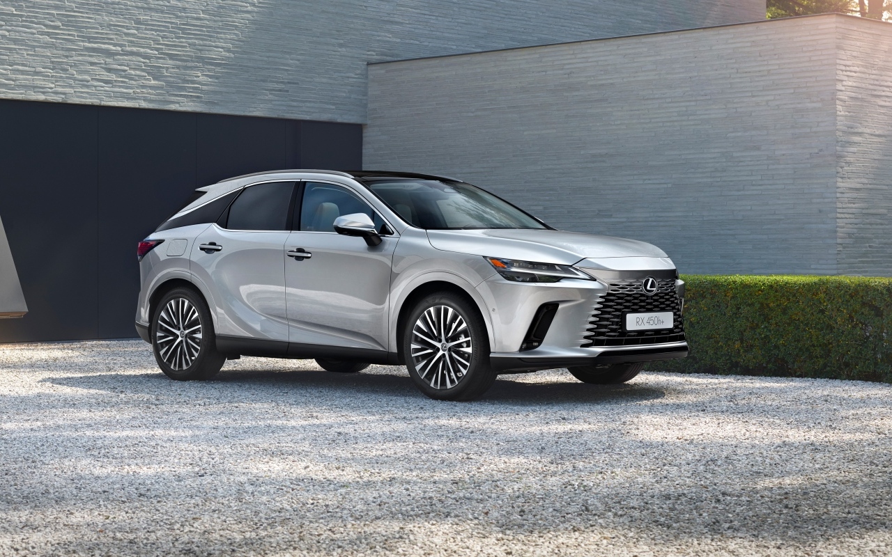Серебристый внедорожник Lexus RX 450h+ у здания