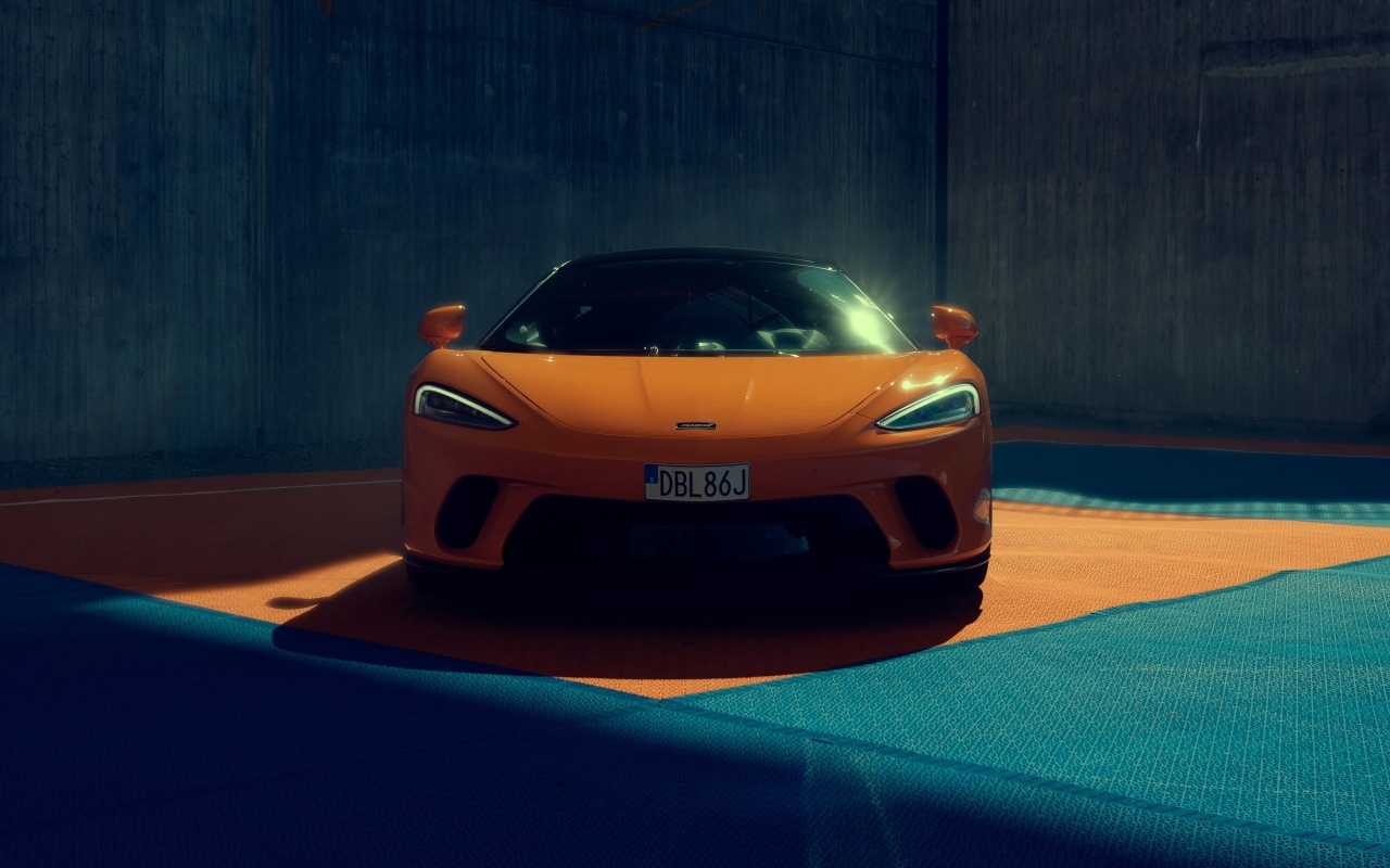 Оранжевый автомобиль McLaren GT вид спереди
