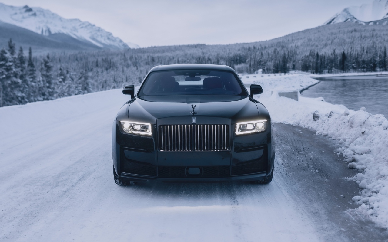 Черный автомобиль Rolls-Royce Black Badge Ghost  на зимней дороге