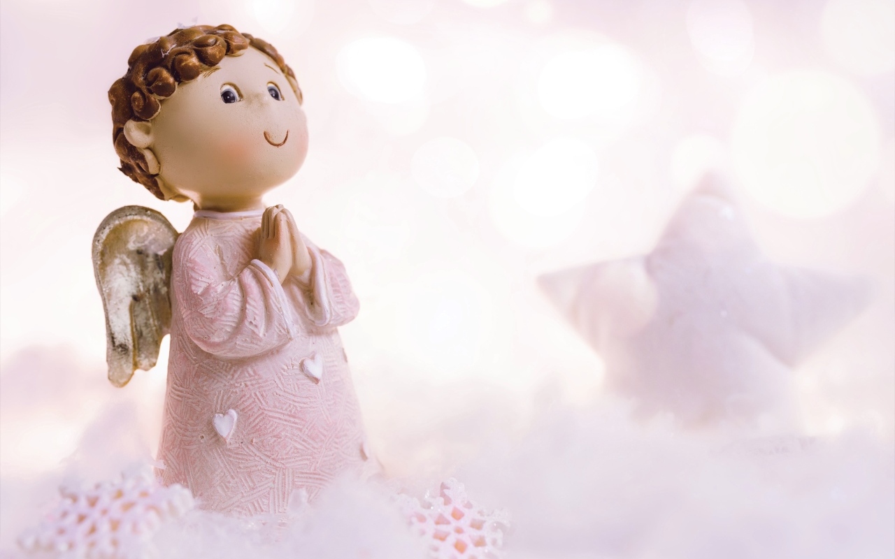 Маленькая статуэтка ангела стоит на снегу
