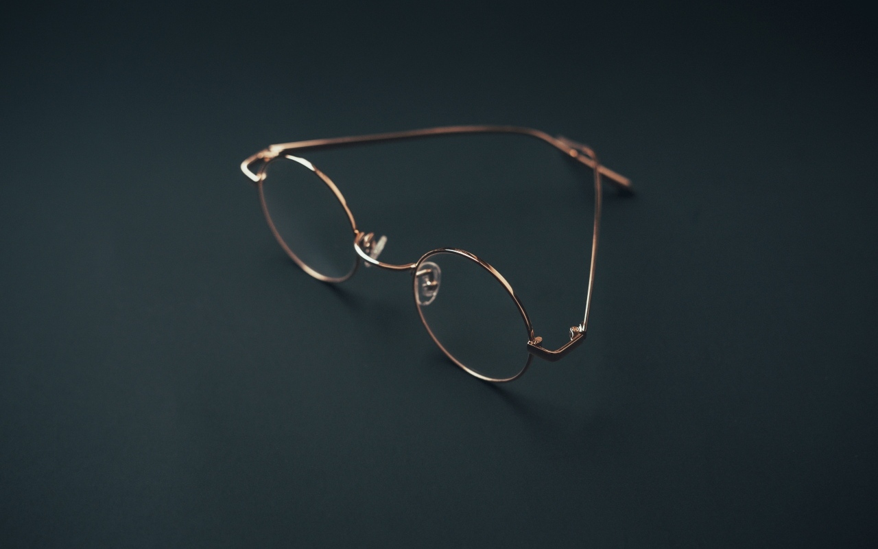 Очки лежат на серой поверхности