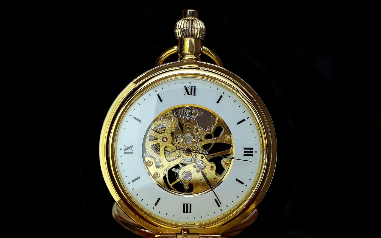 Старинные золотые карманные часы на черном фоне