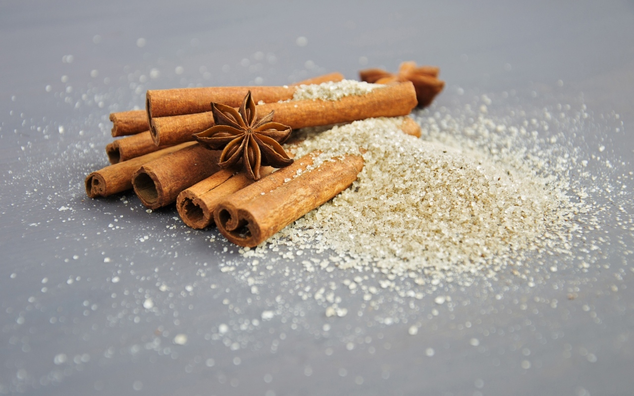 Корица, коричневый сахар и бадьян на сером фоне