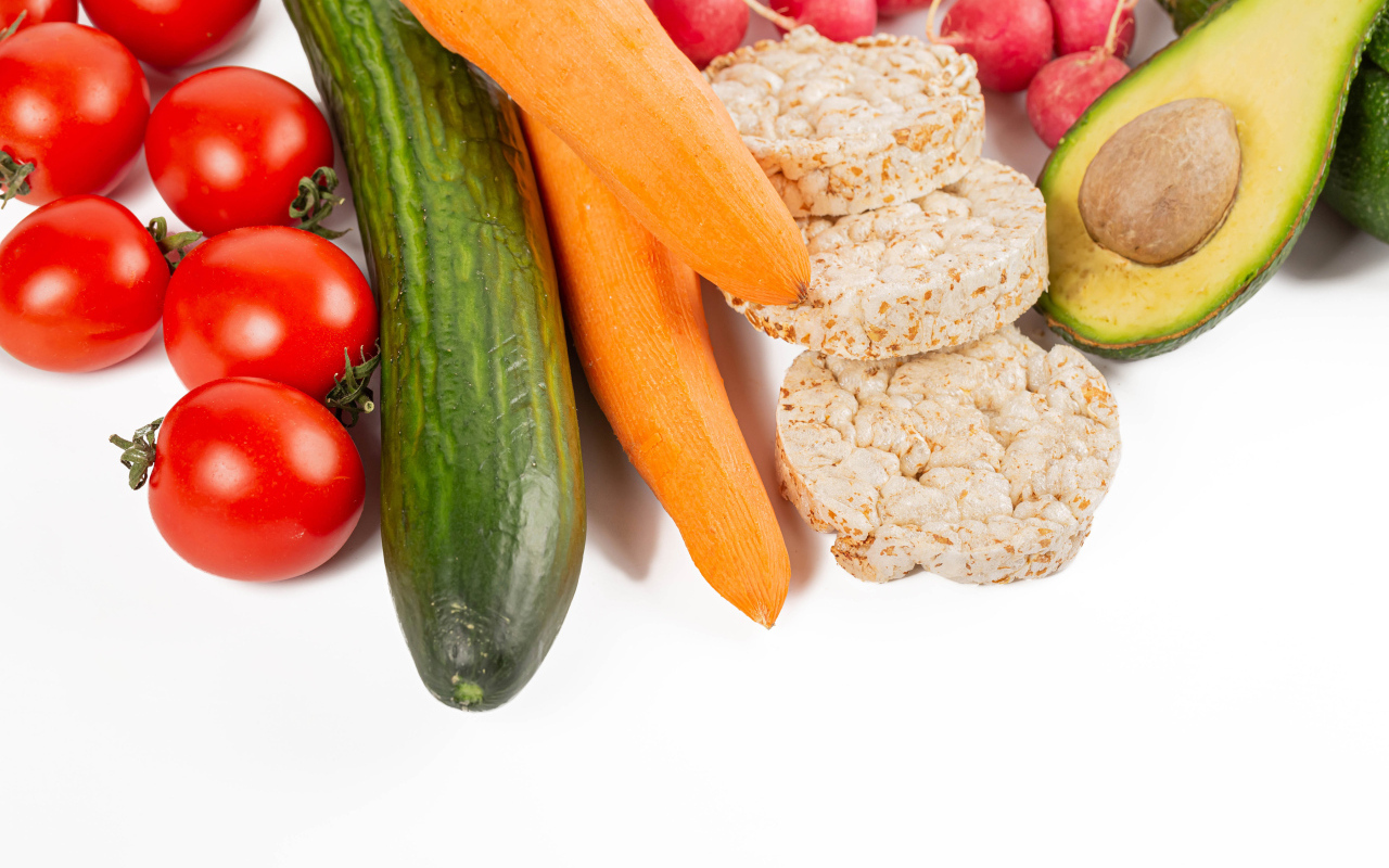 Свежие аппетитные овощи и хлопья на белом фоне