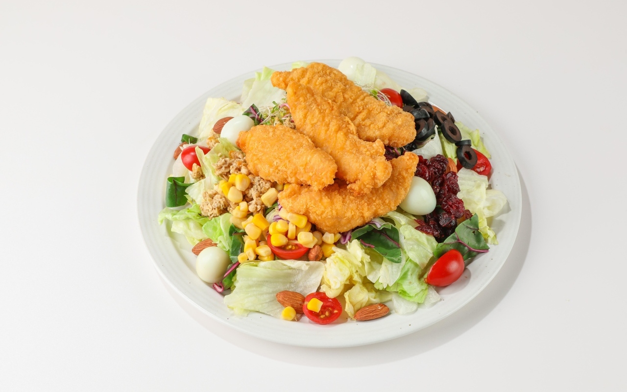 Салат с жареной курицей на сером фоне