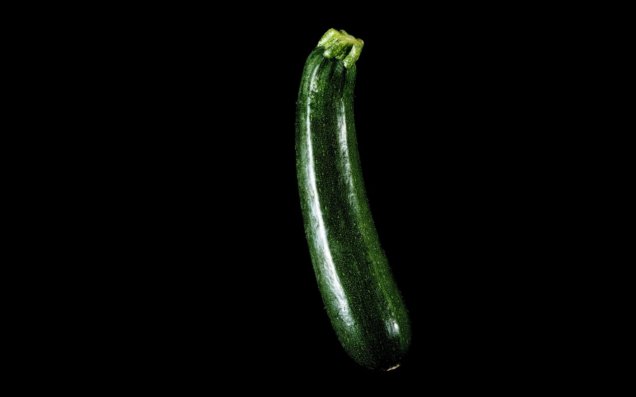 Зеленый кабачок на черном фоне