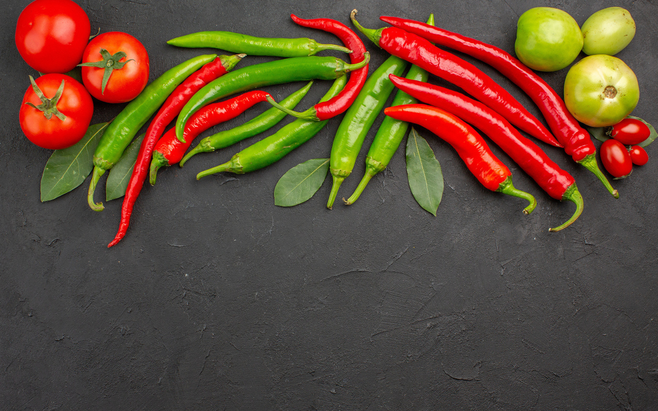 Острый перец чили на столе с помидорами