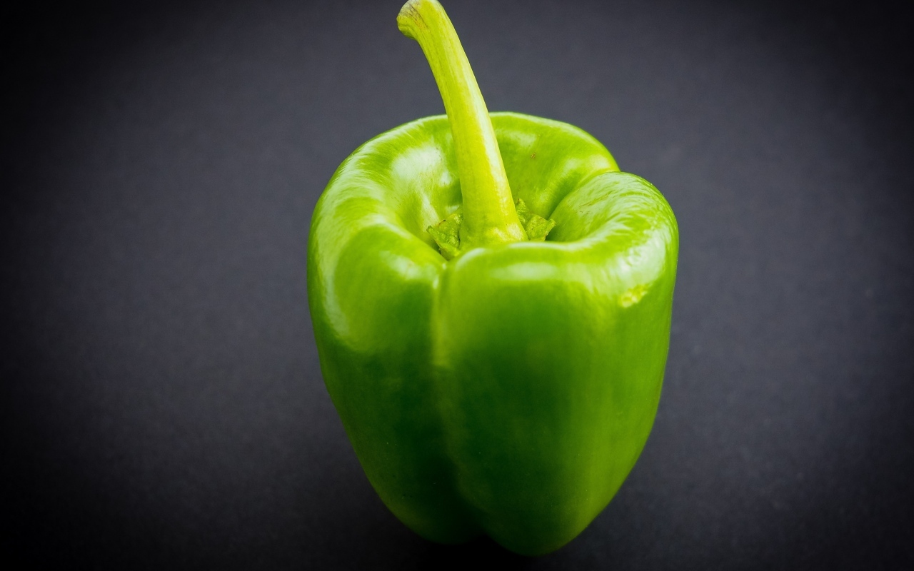 Большой зеленый перец на сером  фоне