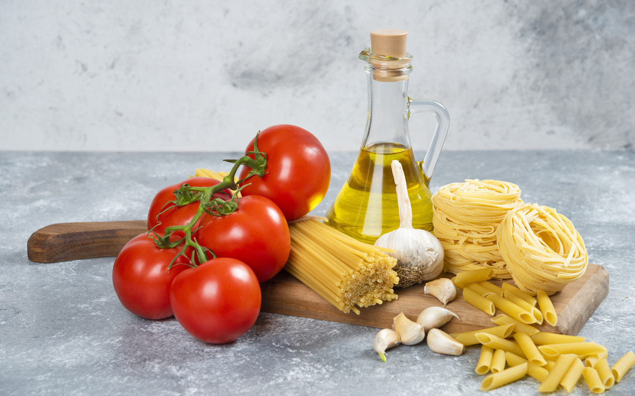Паста, помидоры и масло на столе