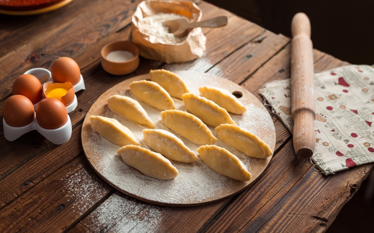 Вареники на столе с мукой и яйцами