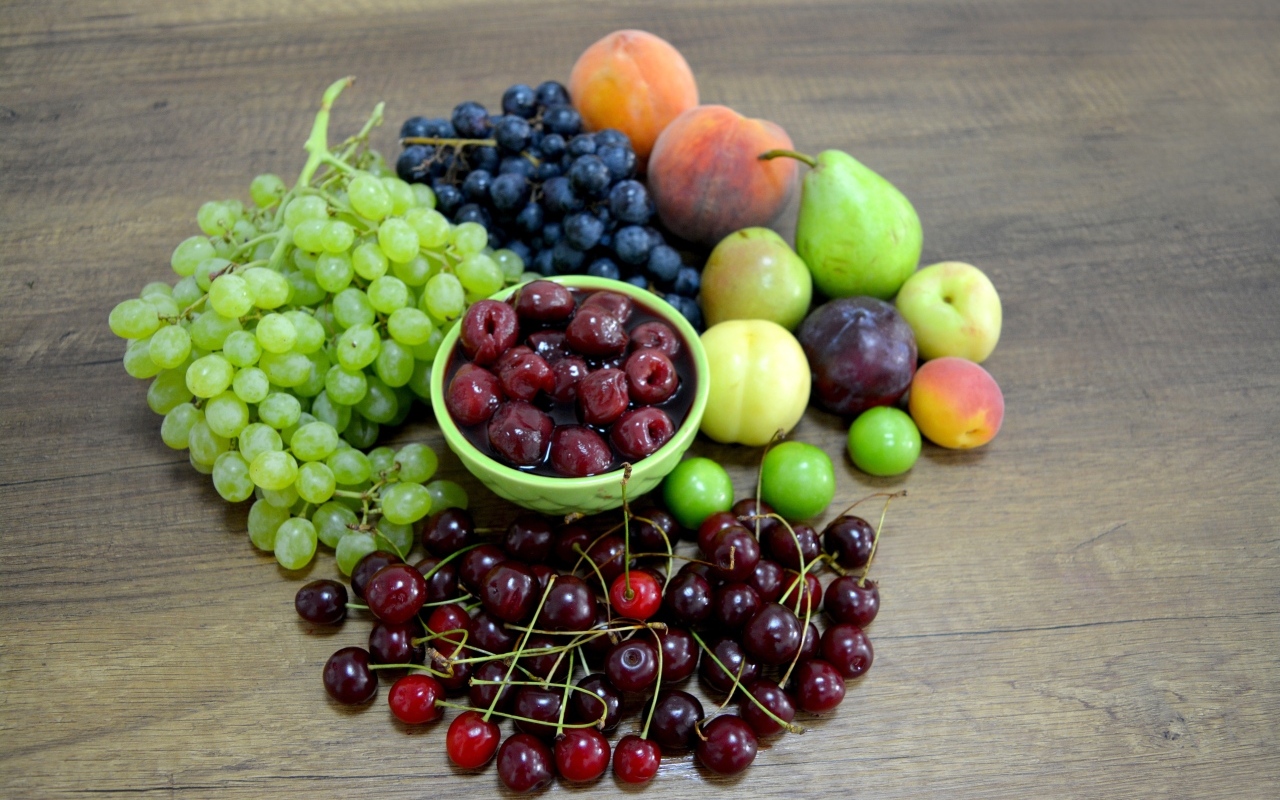 Аппетитные сладкие фрукты и ягоды на деревянном столе