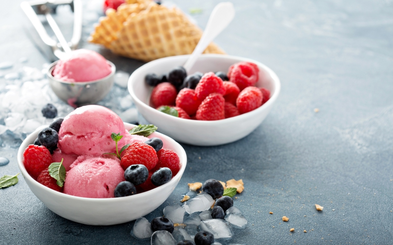Сладкие ягоды с шариками мороженого на столе