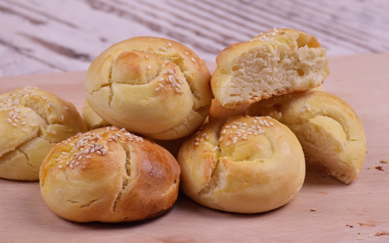 Аппетитные сладкие булочки с кунжутом на столе