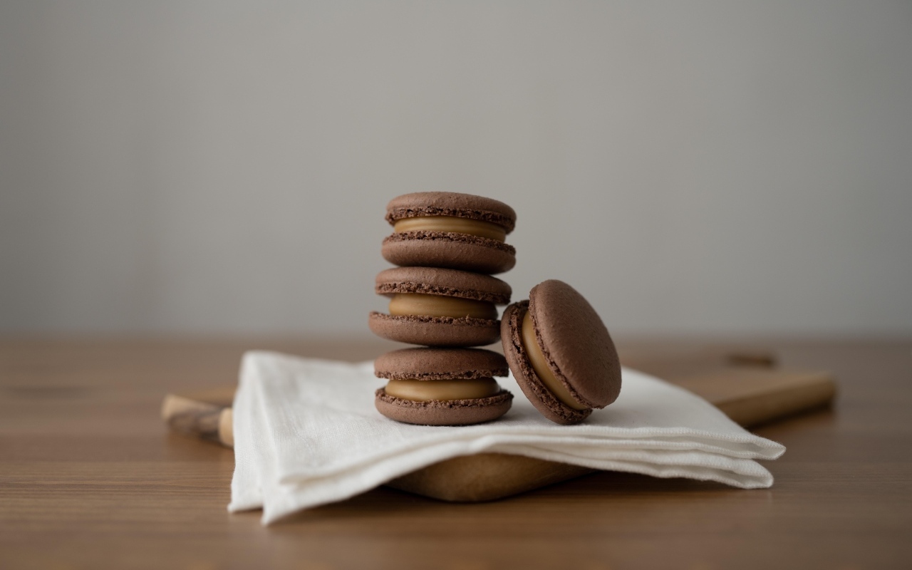 Шоколадный десерт макаронс на столе с салфеткой