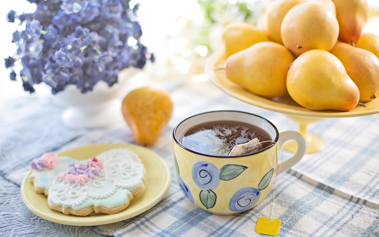 Чашка чая на столе с грушами и печеньем