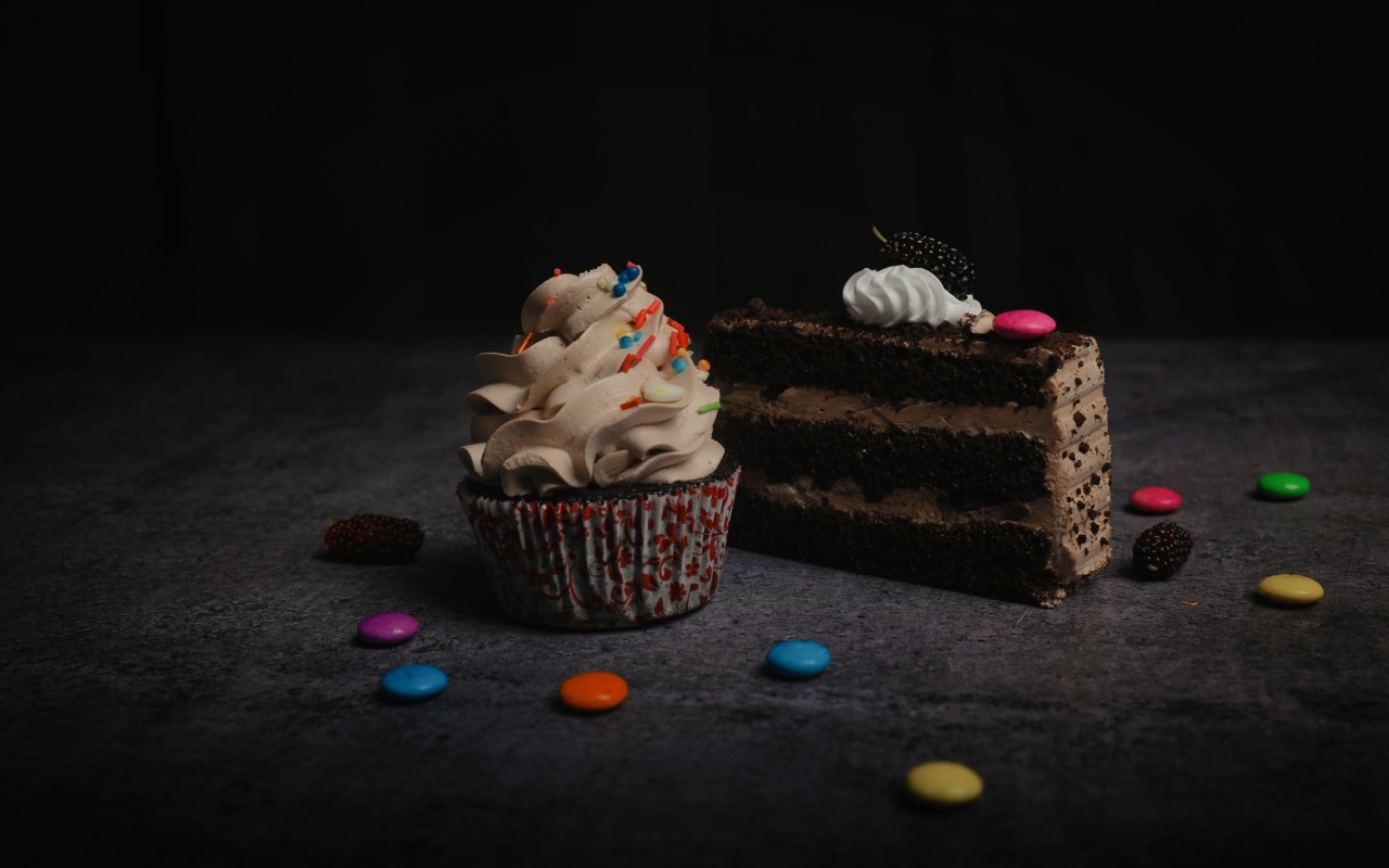 Кусок торта и кекс с кремом на столе