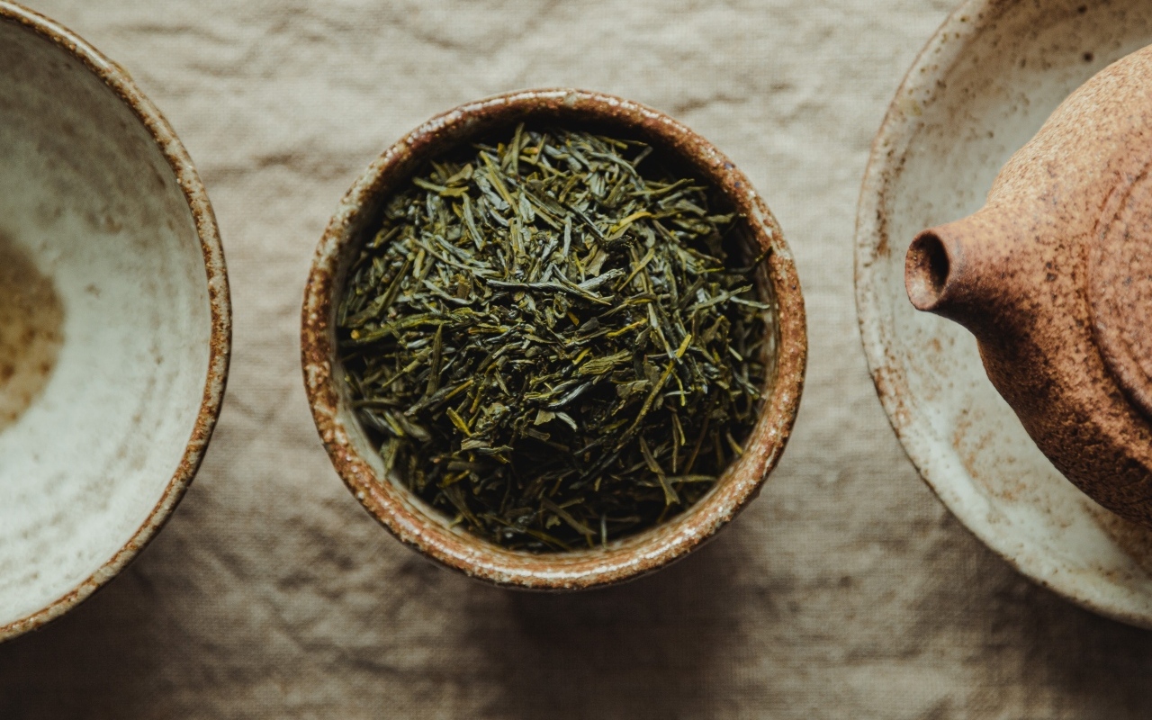 Зеленый чай в пиале на столе с чайником