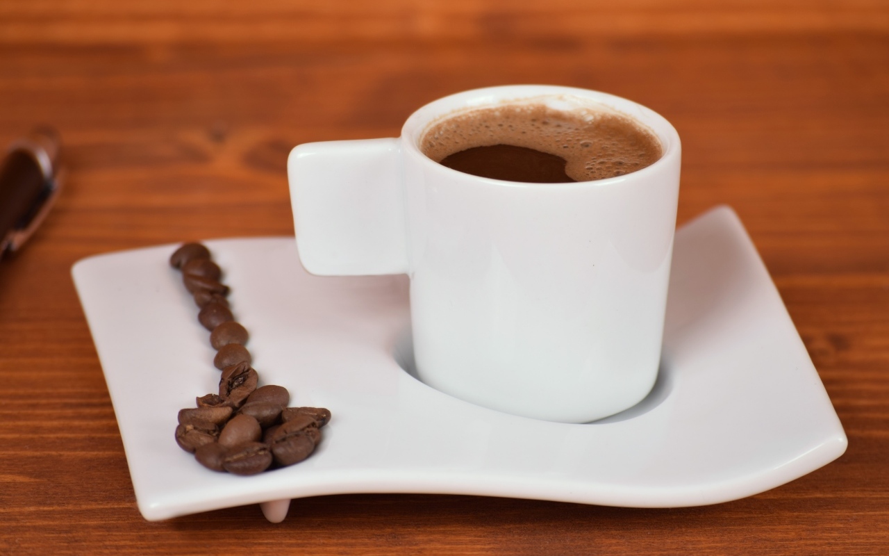 Белая чашка горячего кофе на столе 