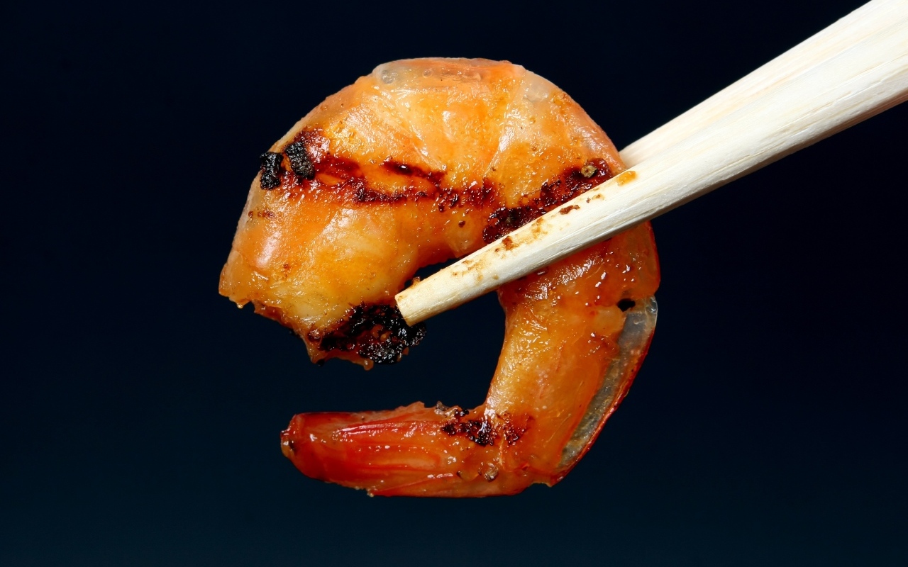 Жареная креветка с палочками на черном фоне