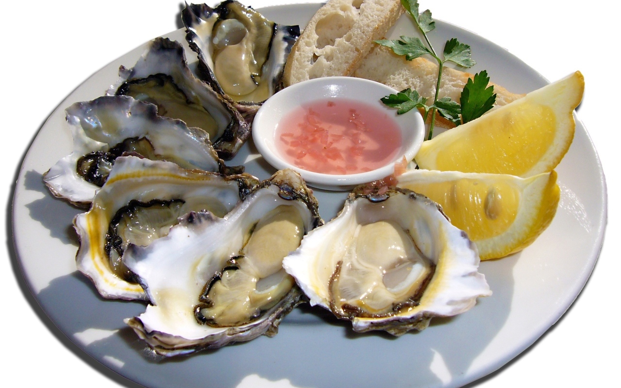 Устрицы  на белой тарелке с лимоном