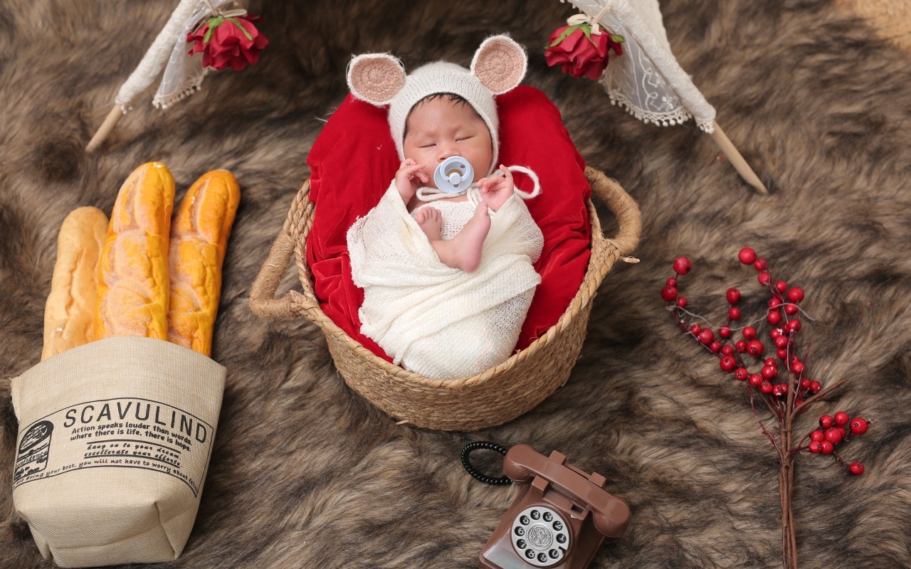 Ребенок спит в корзине с соской во рту