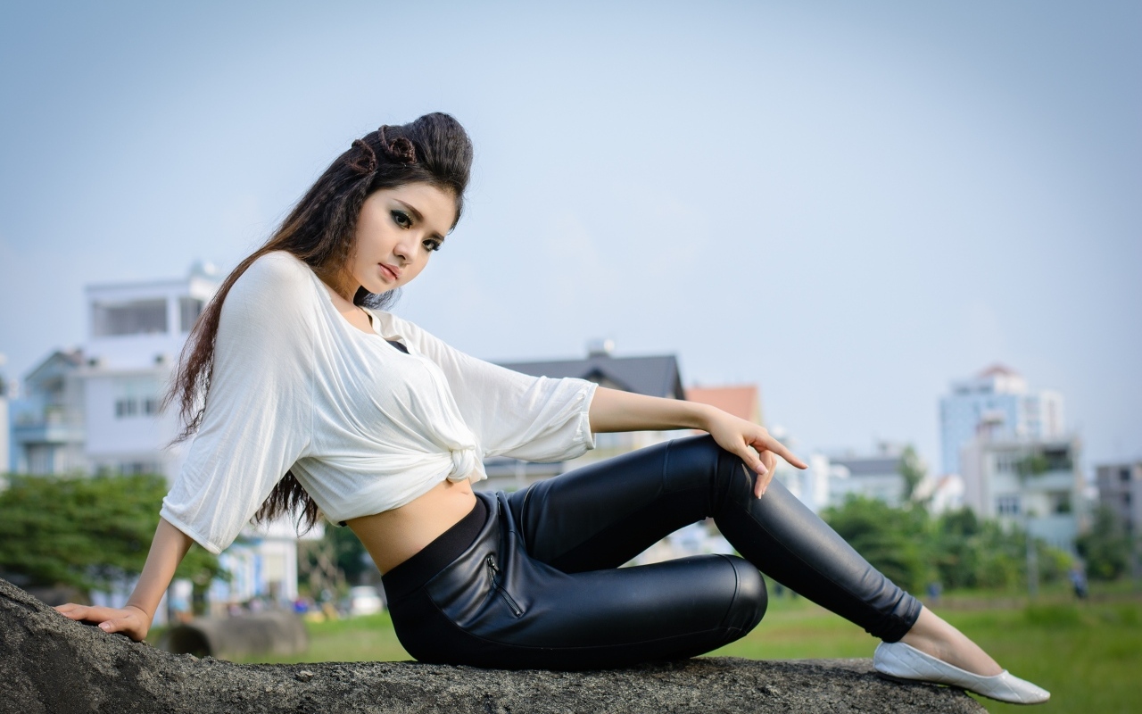 Девушка азиатка в черных кожаных брюках