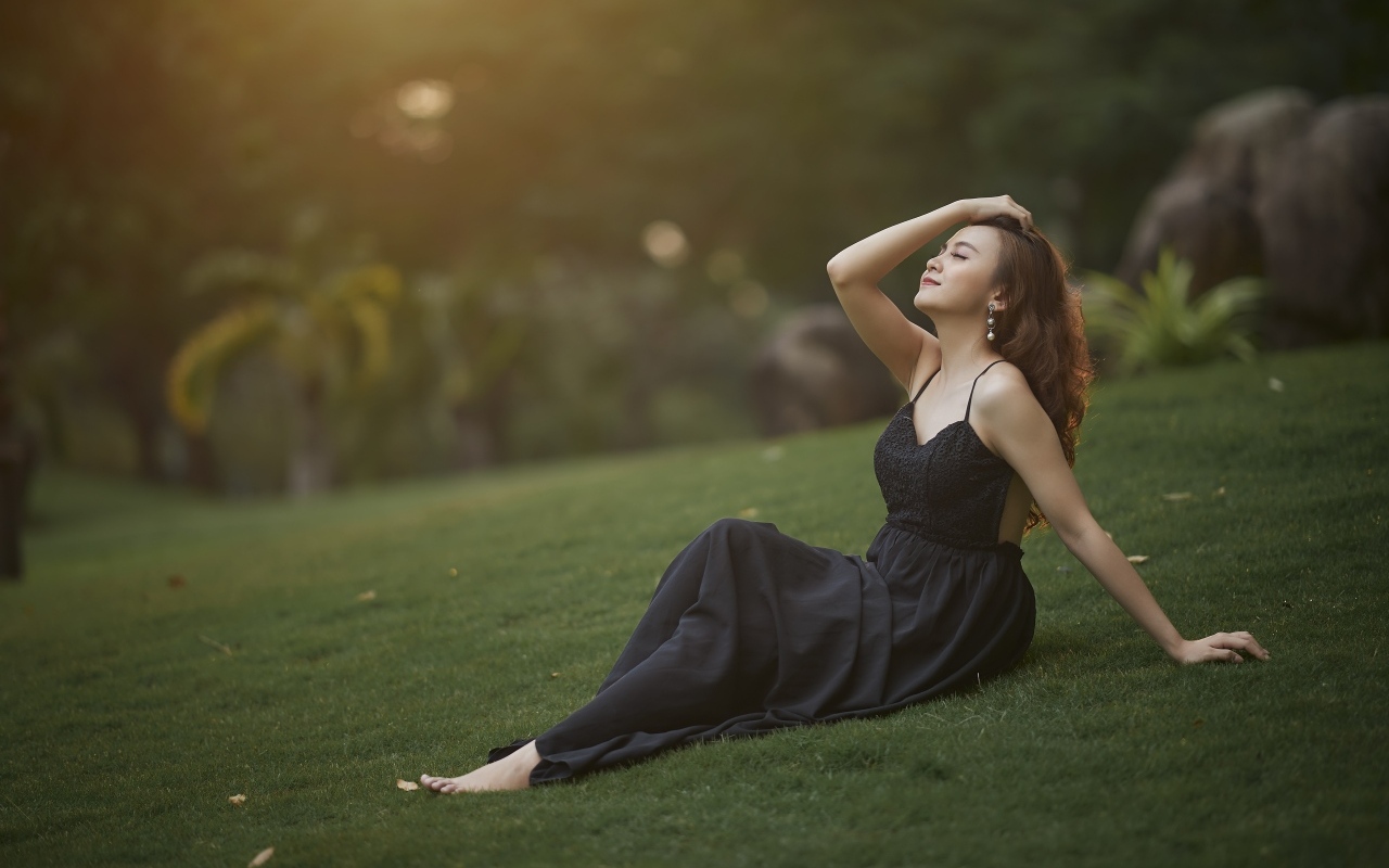 Красивая азиатка с закрытыми глазами в черном платье