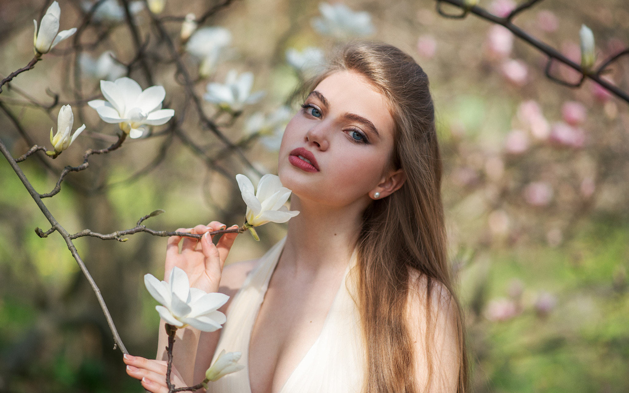 Красивая девушка с белыми цветами магнолии