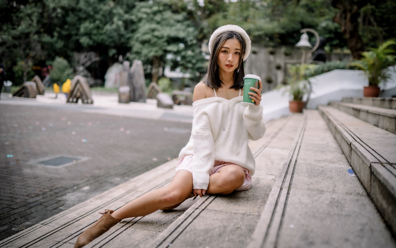 Милая азиатка в с кофе в руках 