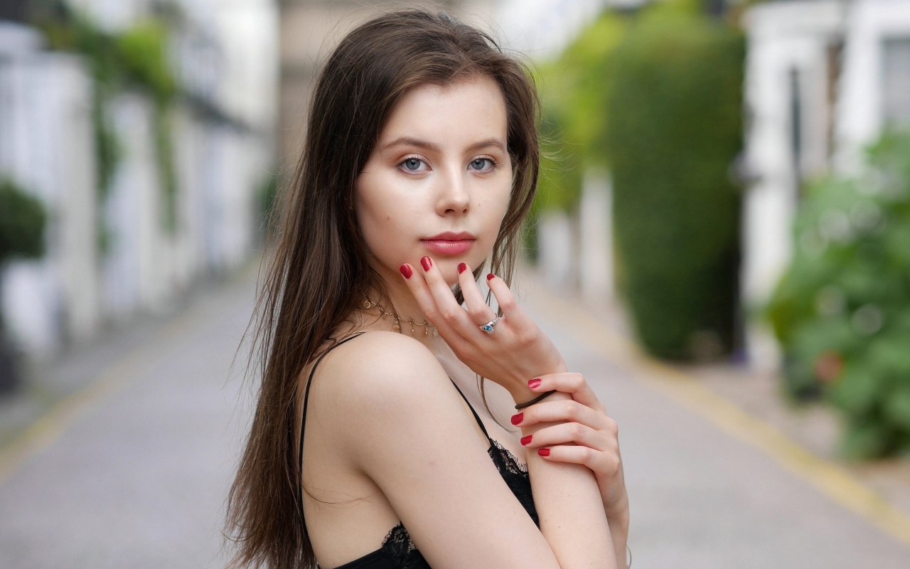 Милая голубоглазая девушка с красным маникюром