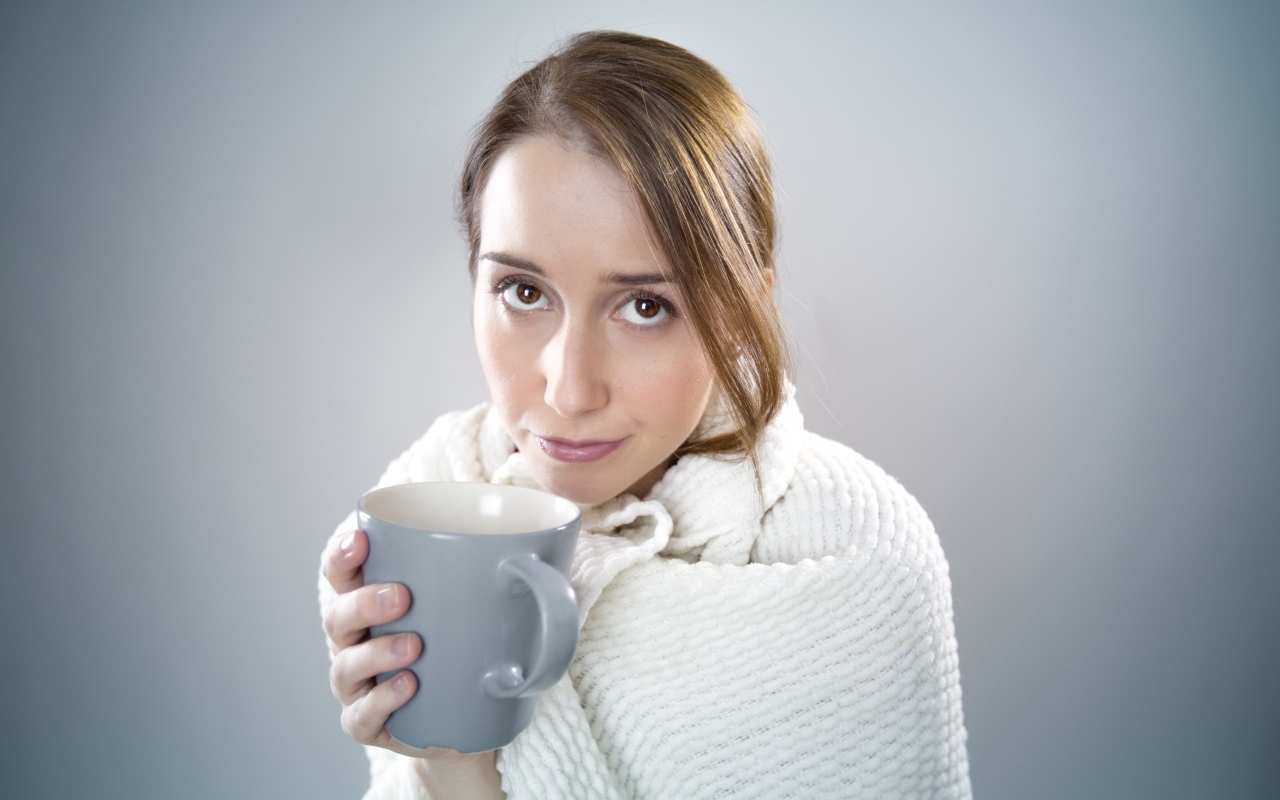 Девушка в белой кофте с кружкой в руке