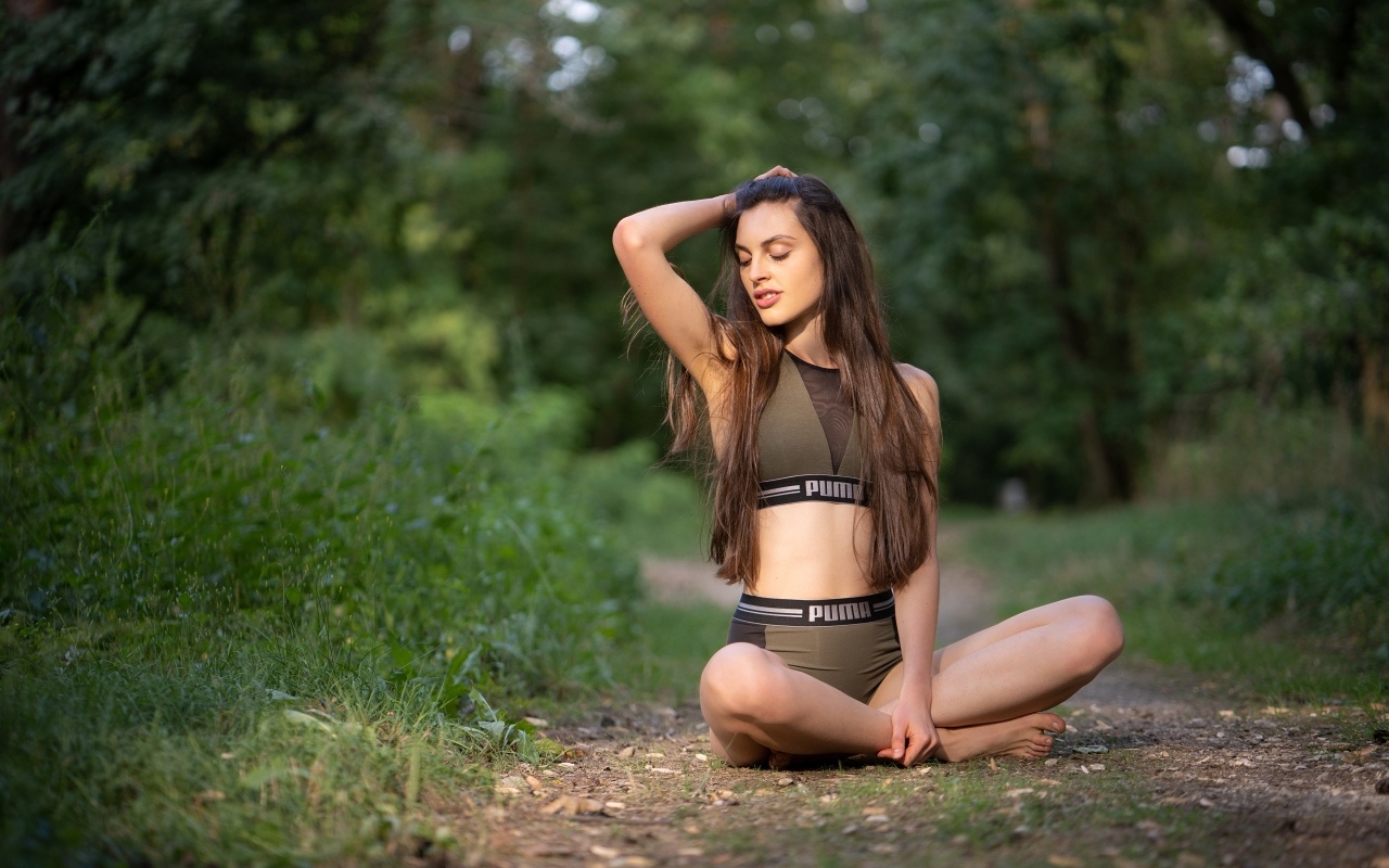 Девушка сидит в позе лотоса в осеннем парке