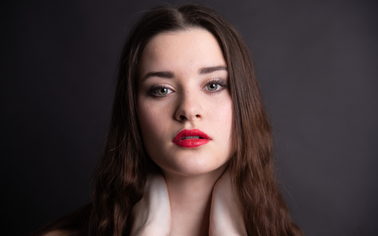 Девушка с красными губами на сером фоне