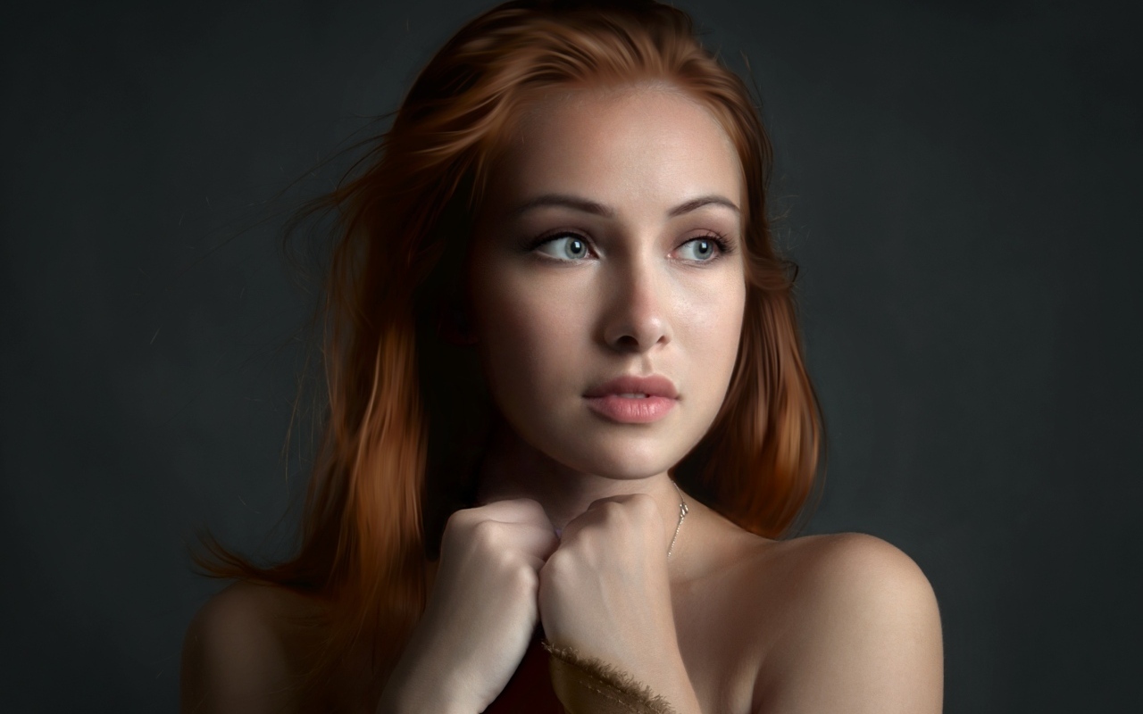 Рыжеволосая девушка с красивыми серыми глазами на сером фоне