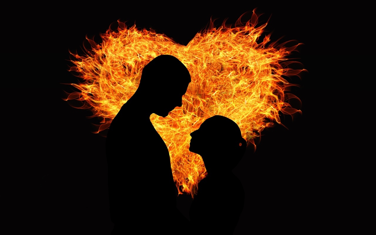 Силуэт влюбленной пары на фоне огненного сердца