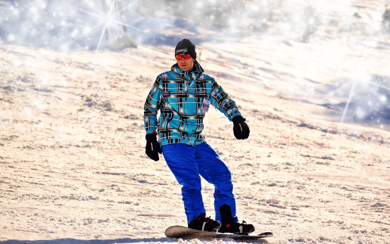 Мужчина сноубордист спускается по склону