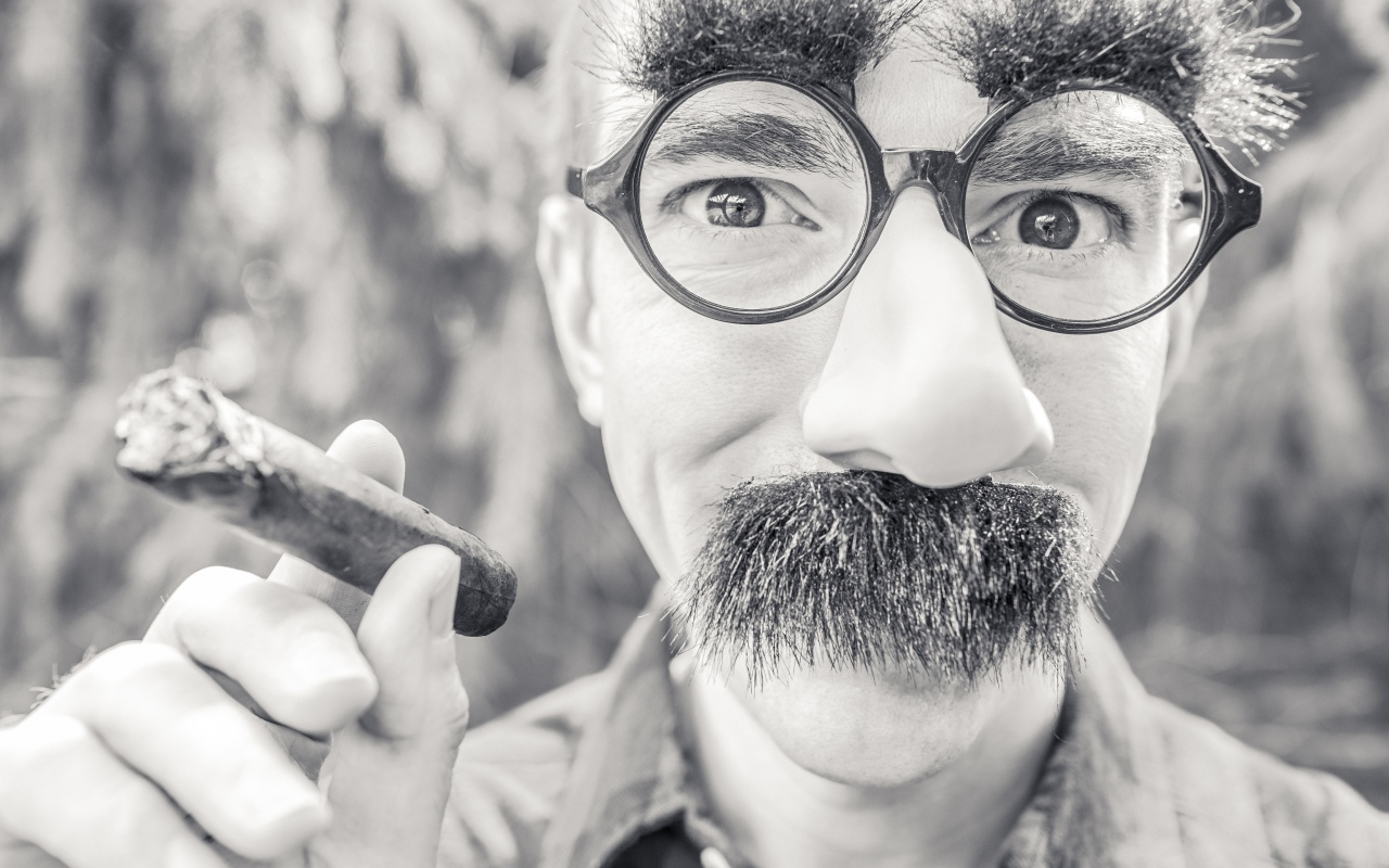 Мужчина в очках с сигарой в руке