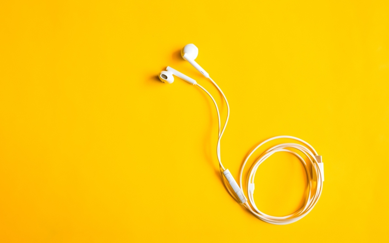 Белые наушники на желтом фоне