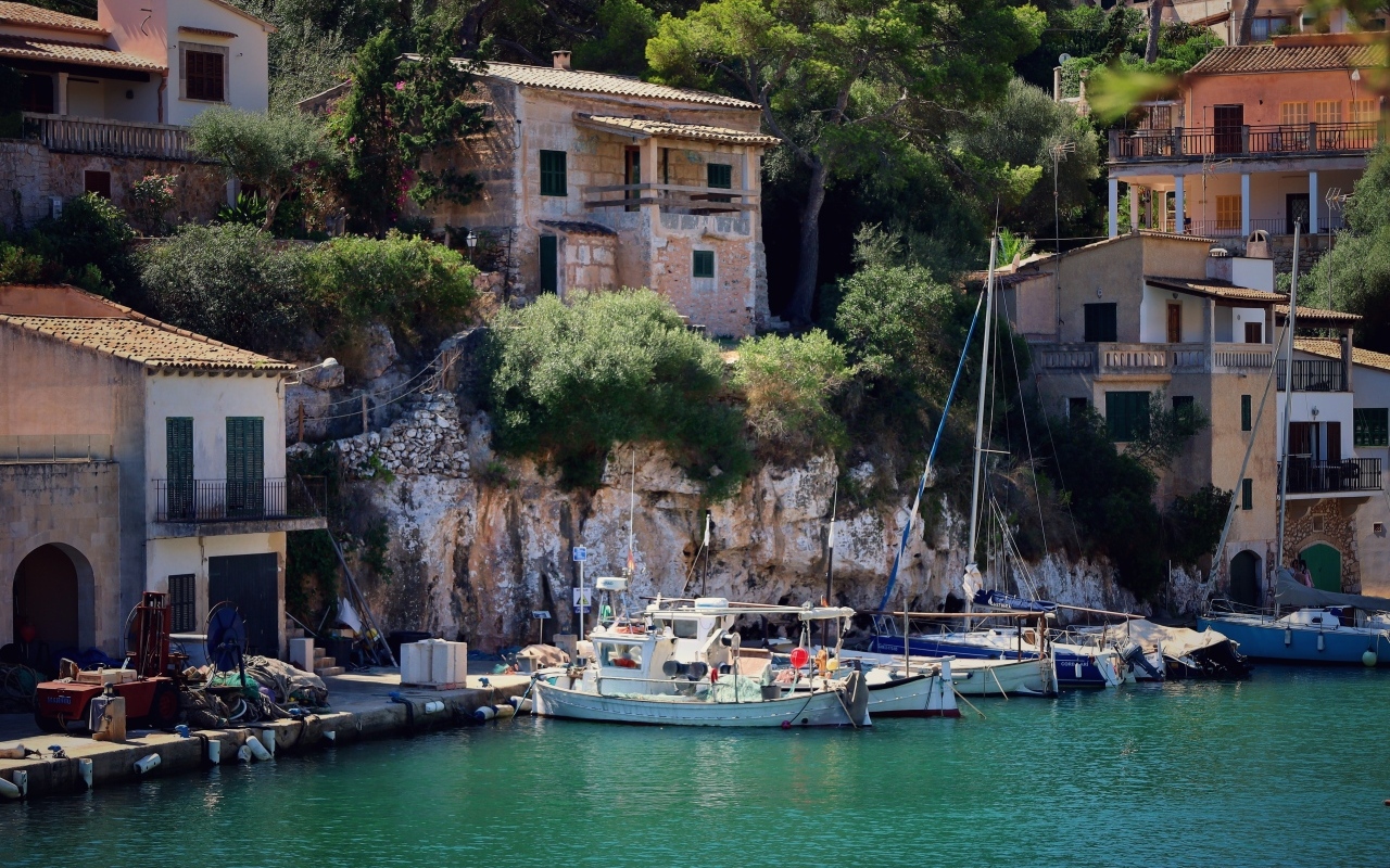 Лодки в воде у причала у домов