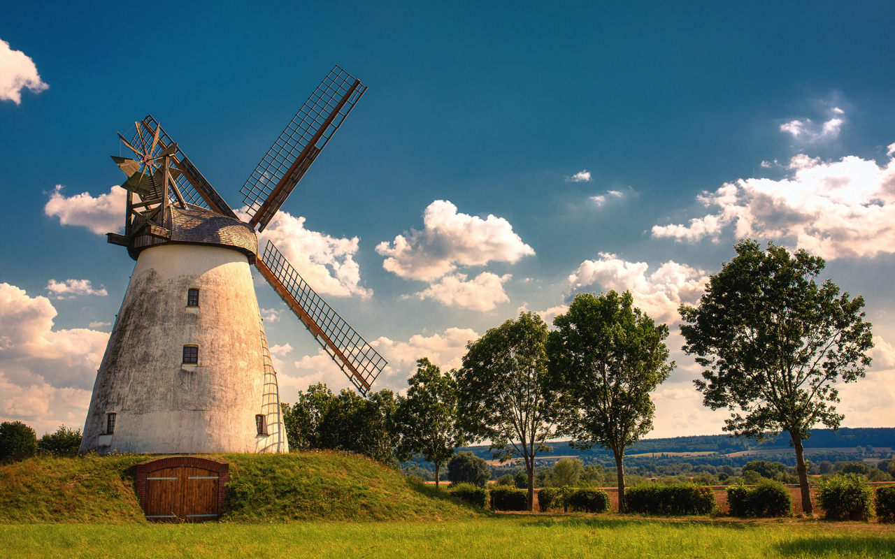 Старая мельница с зелеными деревьями