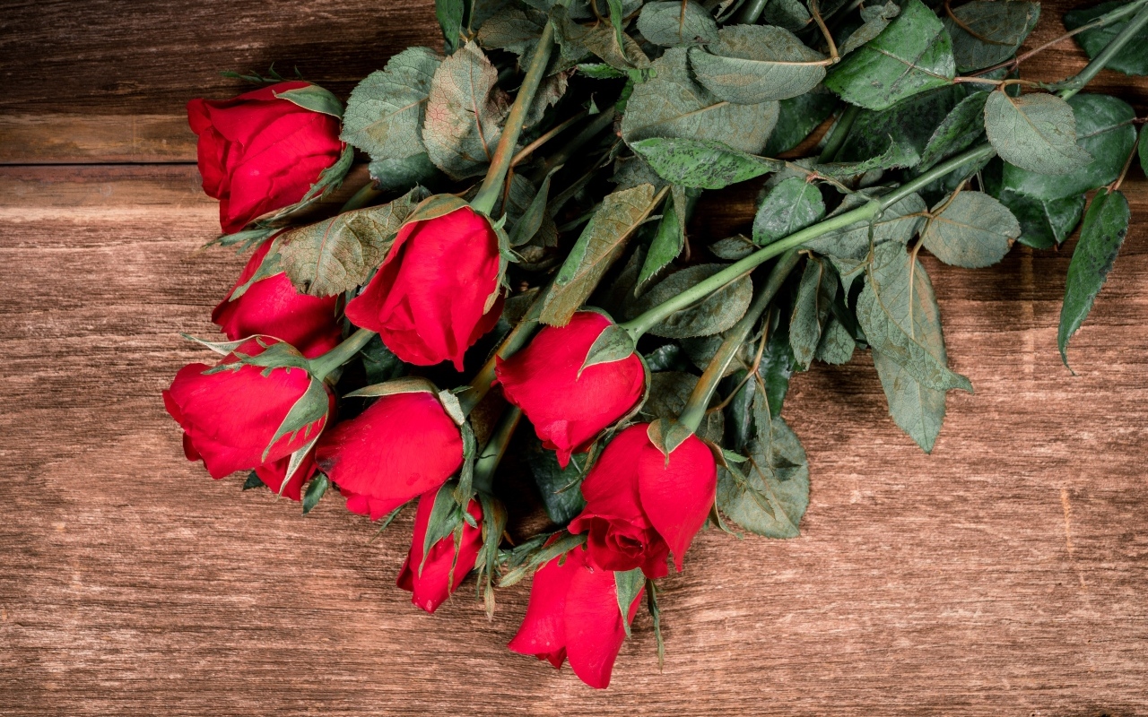 Букет красных английских роз на деревянном столе