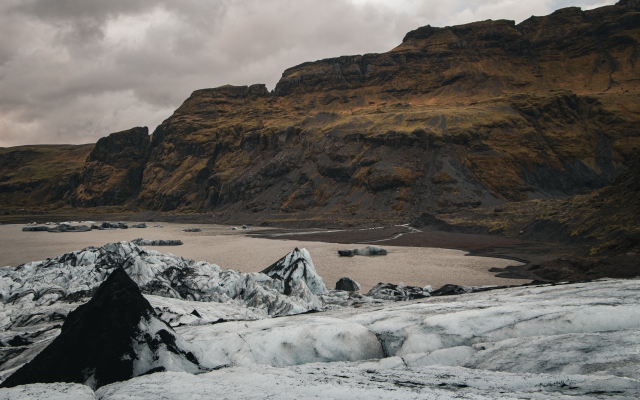 Холодный грязный снег на берегу моря у гор 
