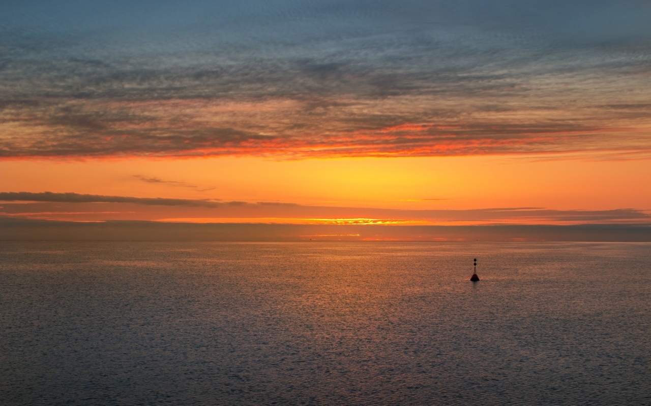 Яркий оранжевый закат на морском горизонте