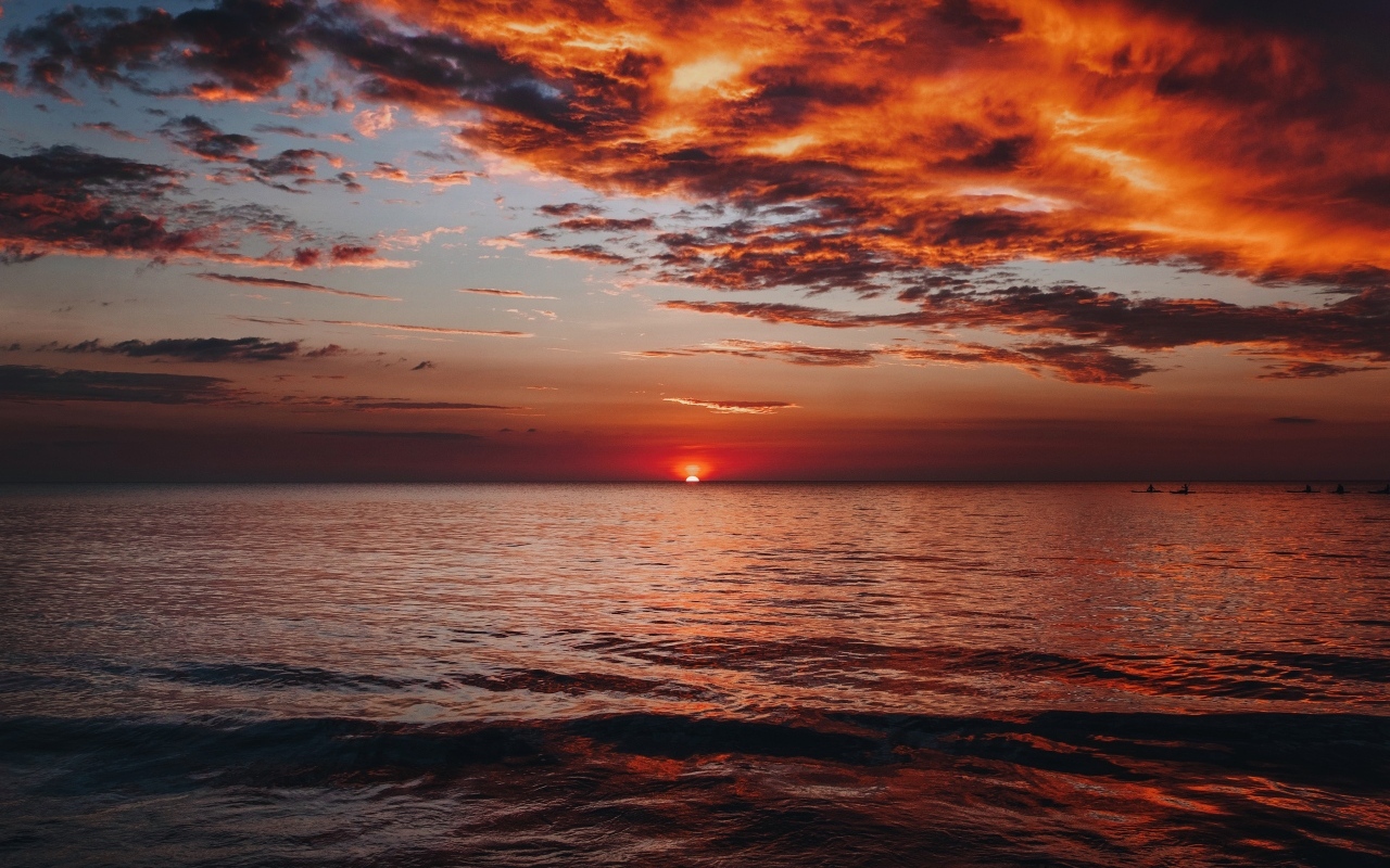 Красные облака в небе над морем на закате