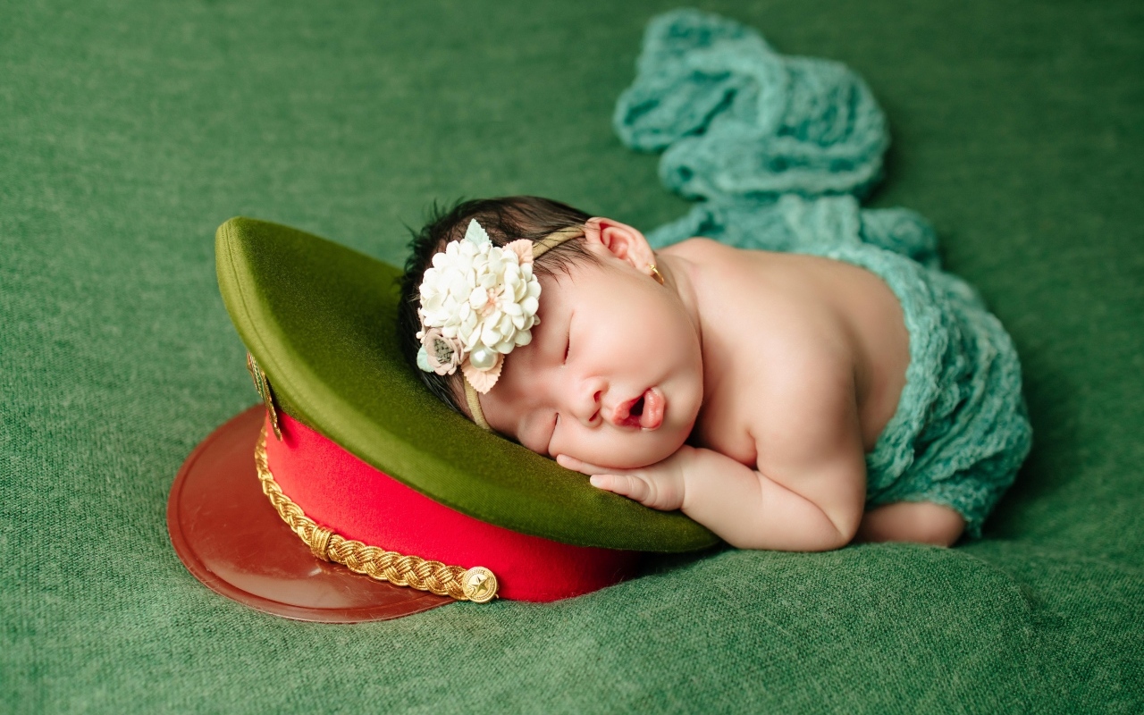 Маленький ребенок спит на военной фуражке